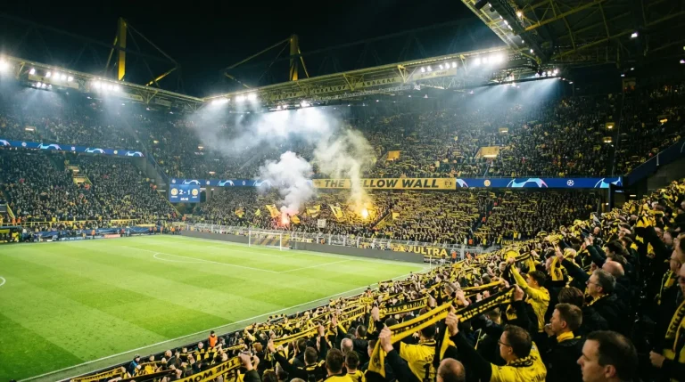 Estadio de fútbol lleno de aficionados locales animando a su equipo desde las gradas